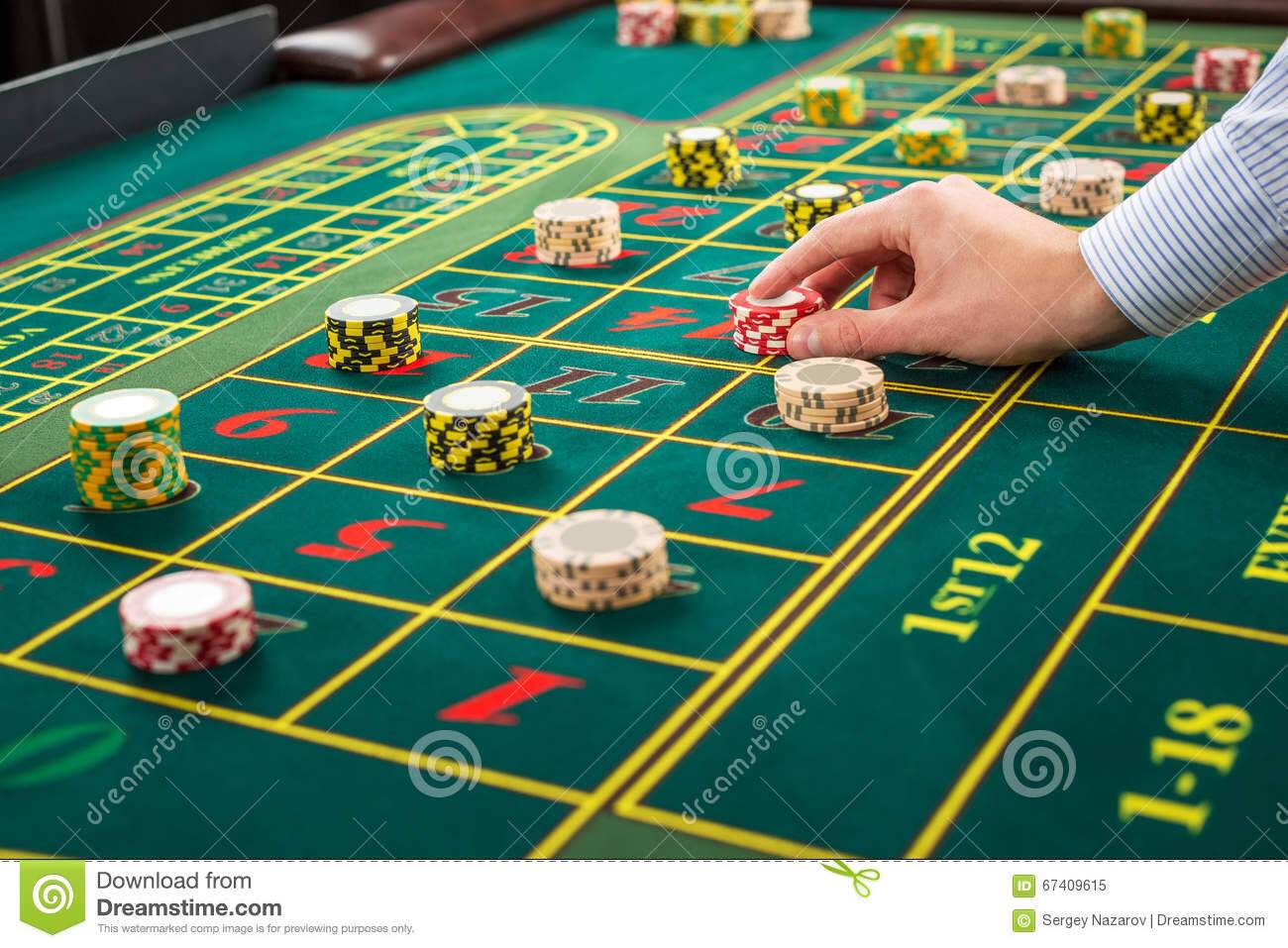 /nfts/green-chip-fund/picture-green-table-betting-chips-man-hand-over-casino-roulette-close-up-67409615.jpg